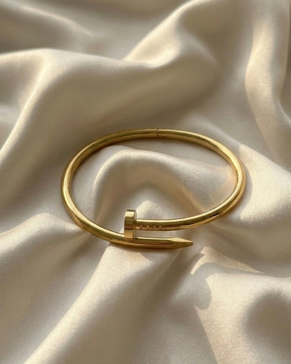 Gold bracelet on a textured beige fabric background