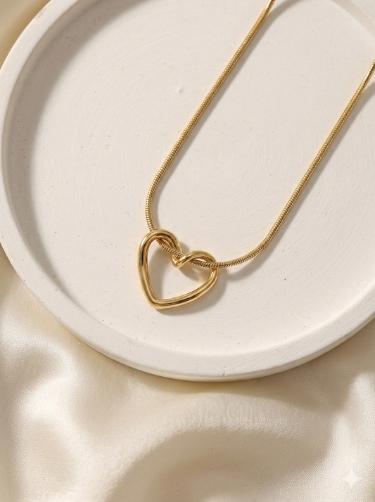 Gold heart-shaped necklace on a white plate